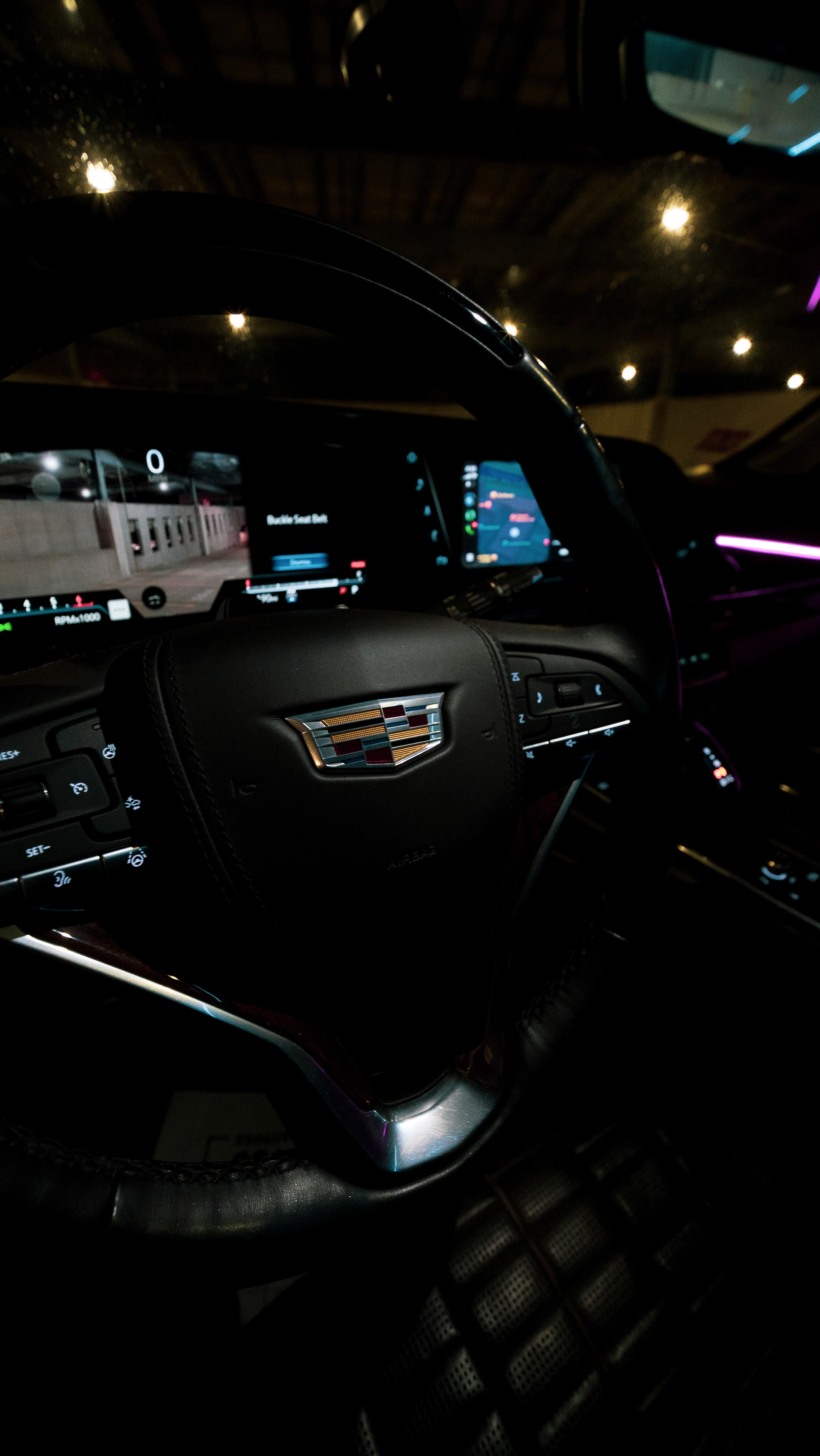 Cadillac steering wheel and dashboard with purple ambient lighting