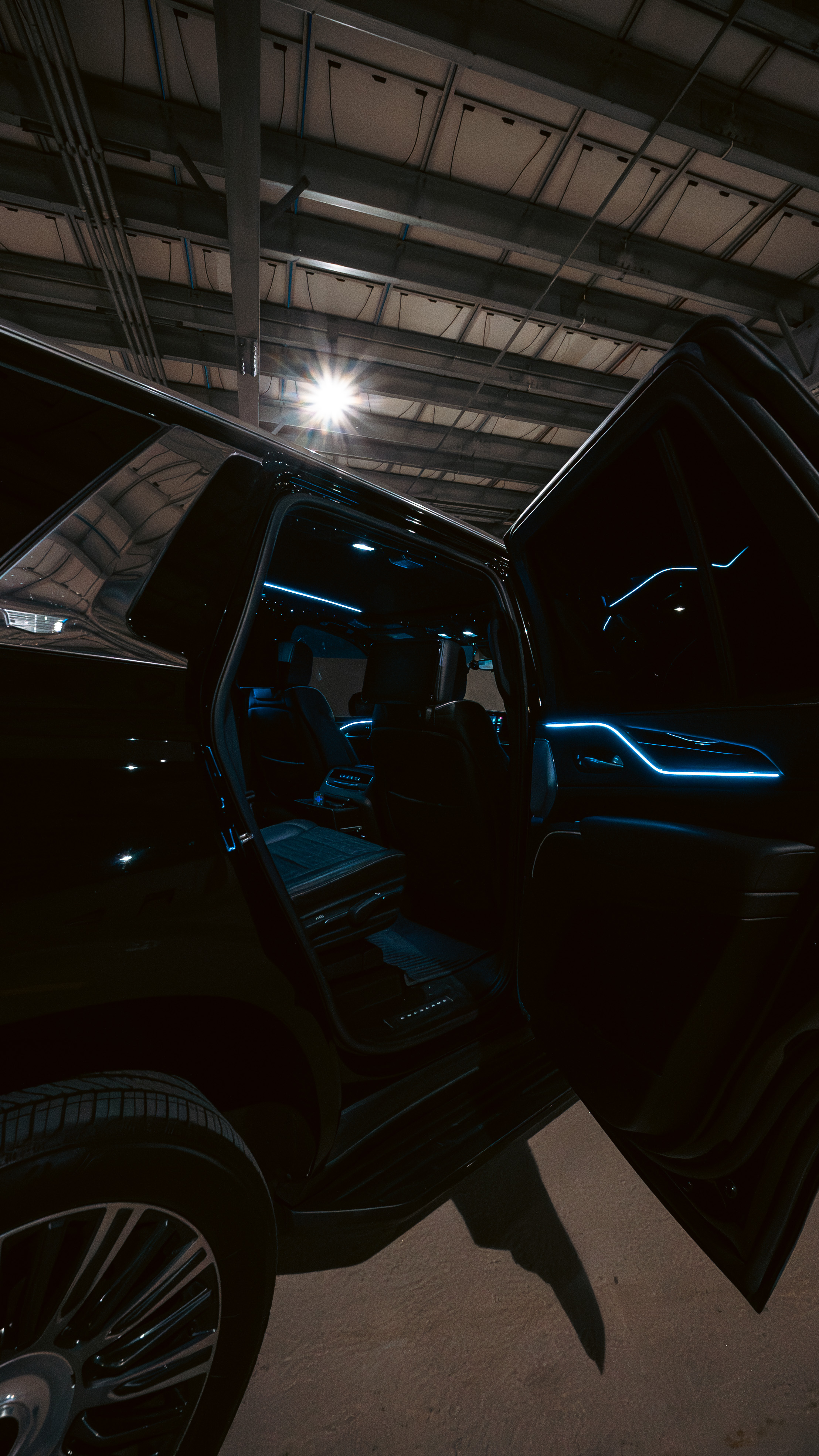 Escalade with rear door open revealing blue ambient interior lighting